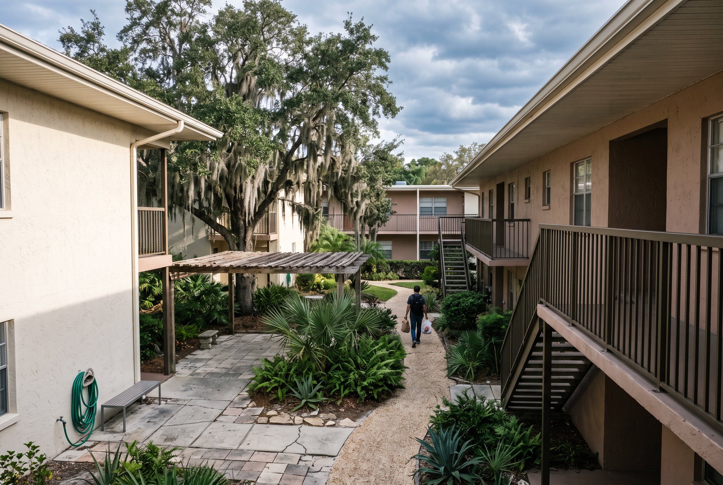 Two-storey courtyard housing with balconies around a planted courtyard.
